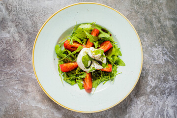 Delicious salad featuring arugula, ripe tomatoes, and creamy cheese, ideal for a sunny afternoon