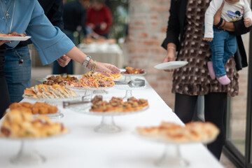 Guests select delicious food from a well-appointed buffet table during a private event gathering with family and friends celebrating a special occasion