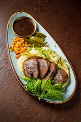 A stunning plate features juicy meat, creamy mashed potatoes, and vibrant sides for dinner