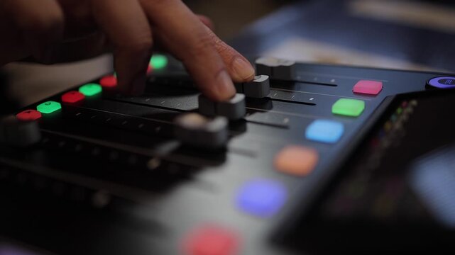 Audio mixer: Fingers slide tracks 2 and 3 faders on sound console