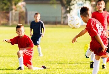 Obraz premium Kids soccer football - children players match on soccer field