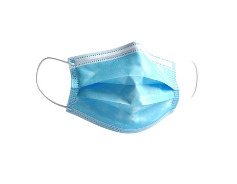 A light blue disposable face mask, isolated against a black background
