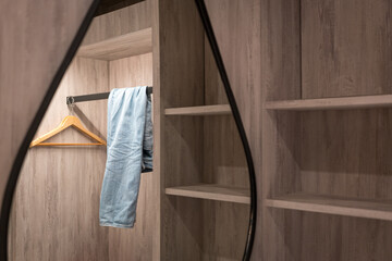 Wardrobe with clothes, hanger, mirror and open shelves.