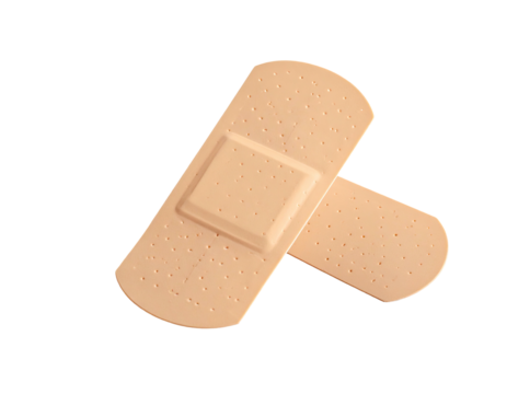 Two beige adhesive bandages cross on black background, showing textured surfaces