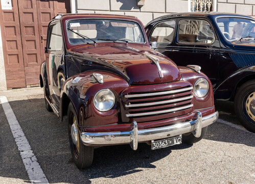 Old red car,  Fiat 500c, built in 1949, on exhibition during a vintage car rally in Varallo Sesia, Italy, on September 29, 2025