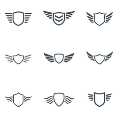 Collection of nine dark grey shield emblems with wings on white background badge crest