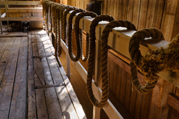 Ropes hanging on a wooden railing inside a historic building