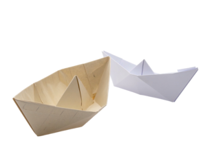 Two handmade paper boats, one beige, one white, isolated on a black background