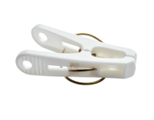 A white plastic clasp with a gold ring rests on a solid black background