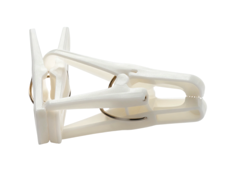 Close-up of a single white plastic laundry clip against a black background