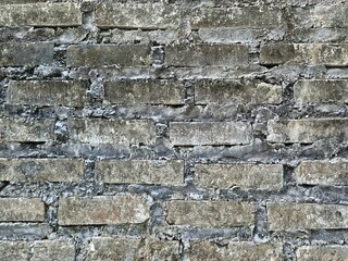 Close up view of old weathered brick wall with rough cement and textured stone surface