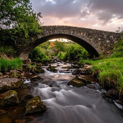 Old stone arch bridge over river at dusk