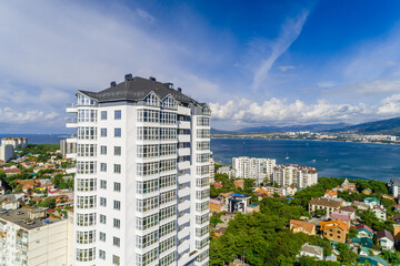 Fototapeta premium New multi-storey residential building in resort of Gelendzhik. Aerial view. View of Black Sea, Gelendzhik Bay and Caucasus Mountains.