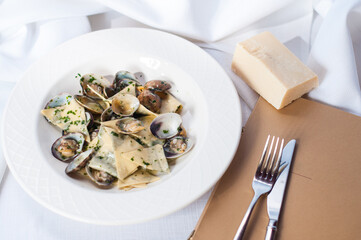 mussels in a creamy sauce with cheese on a white plate