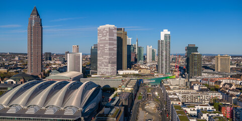 Aerial view of the Messeturm skyscraper and Messe Frankfurt exhibition center under a clear blue sky, Frankfurt am Main, Hesse, Germany.