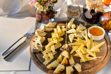 large cheese slices on a round wooden board