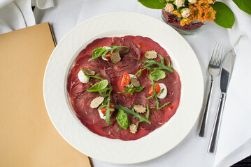veal carpaccio on a plate on the table