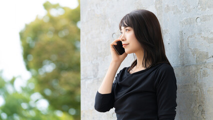 スマートフォンで話す女性・ビジネスウーマン