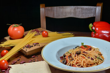 vegan pasta with vegetables in a plate on a table with food decor