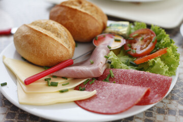 Delicious breakfast plate with bread rolls, cheese, and cold cuts