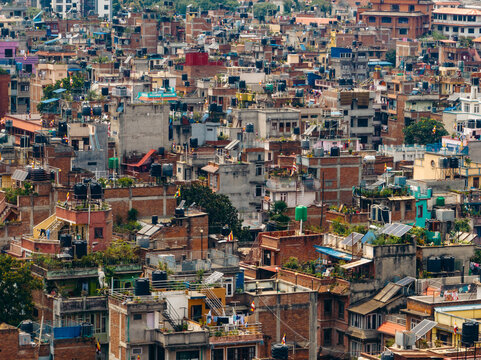 Aerial view of buildings tightly packed with vibrant rooftops and water tanks creating a textured cityscape, Boudha Sadak, Kathmandu, Bagmati Province, Nepal.