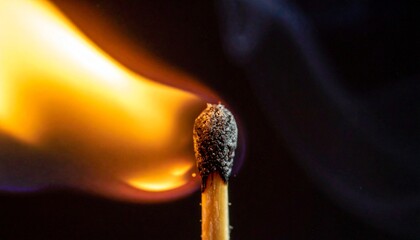 Close-up of a lit matchstick with a bright flame and smoke against a dark background.