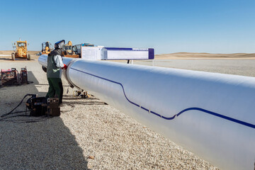 Capture skill and precision. A welder with protective gear creates bright sparks while working on a pipe. Perfect for industry, construction, manufacturing, and skilled labor themes. Safety and