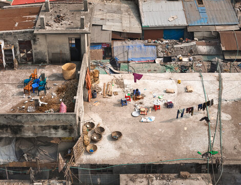 Aerial view of rooftops cluttered with everyday life, laundry lines strung between buildings, and a vibrant display of domesticity unfolds from above, Dhaka, Dhaka Division, Bangladesh.