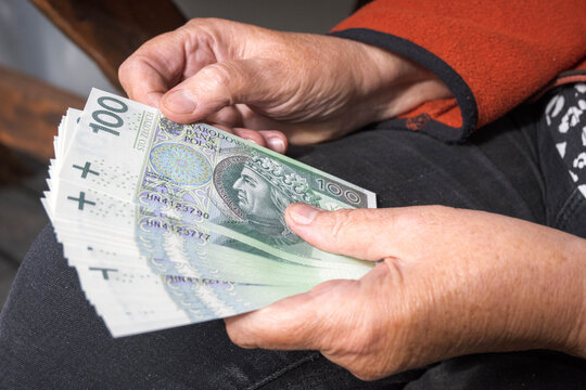 Polish money in the hand of an elderly woman, pension.

