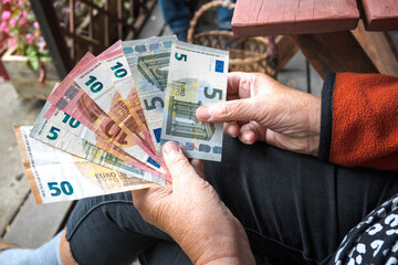 A woman counts euros in her hands.
