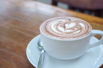 A cup of coffee with latte art on a wooden table