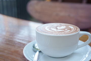 A cup of coffee with latte art on a wooden table