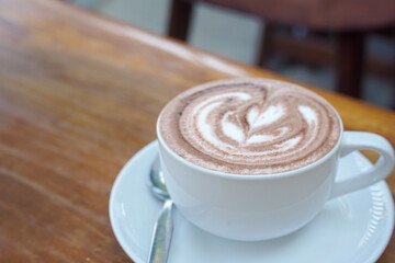 A cup of coffee with latte art on a wooden table