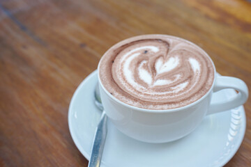 A cup of coffee with latte art on a wooden table