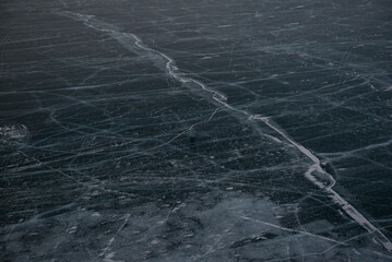 Frozen lake surface with natural ice cracks.