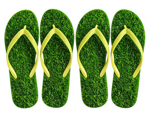 Four green flip-flops with yellow straps, their soles mimicking lush green grass