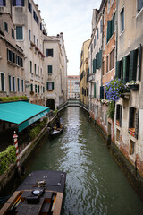 Narrow Venice canal with gondola and bridge 