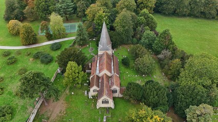 Aerial view of a historic church steeple piercing the skyline, nestled amidst the vibrant green landscape and ancient trees, a timeless scene, Sevenoaks, England, United Kingdom.
