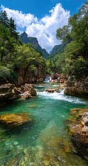 Fototapeta premium Vivid turquoise river flows through a rocky gorge, lush green vegetation and dramatic cliffs under a bright blue sky with fluffy clouds
