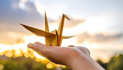 Origami Crane Held in Hand at Sunset with Golden Light
