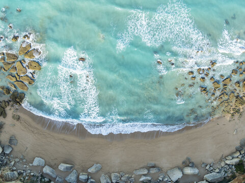 Aerial view of turquoise waters meet a sandy shore dotted with rugged rock formations, creating a mesmerizing coastal tapestry, Roche coves, C&Atilde;&iexcl;diz province, Andalusia, Spain.