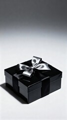 Elegant black gift box adorned with a shiny silver ribbon, placed on a soft gradient background, creating a sophisticated atmosphere perfect for special occasions and celebrations