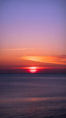 Obraz premium Vibrant sunset over the ocean, painting the sky with hues of purple and orange, creating a serene and breathtaking natural spectacle