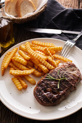 Delicious Grilled Steak with Crispy Fries and Fresh Herbs on Plate