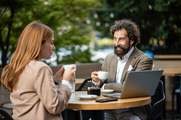 Business people having coffee break outdoors and discussing a project
