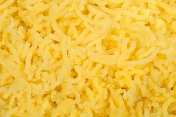 A full frame, close-up view shows a bright yellow texture of freshly riced boiled potatoes