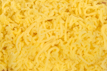 A full frame, close-up view shows a bright yellow texture of freshly riced boiled potatoes