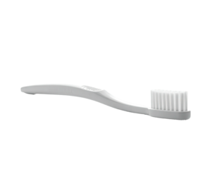A white toothbrush with a rounded head sits against a pure black background