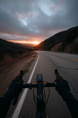 First-Person Point of View (POV) of Cyclist Riding a Road Bike on a Mountain Highway at Sunset