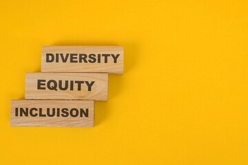 Diversity, Equity, And Inclusion Words On Wooden Blocks Over Yellow Background